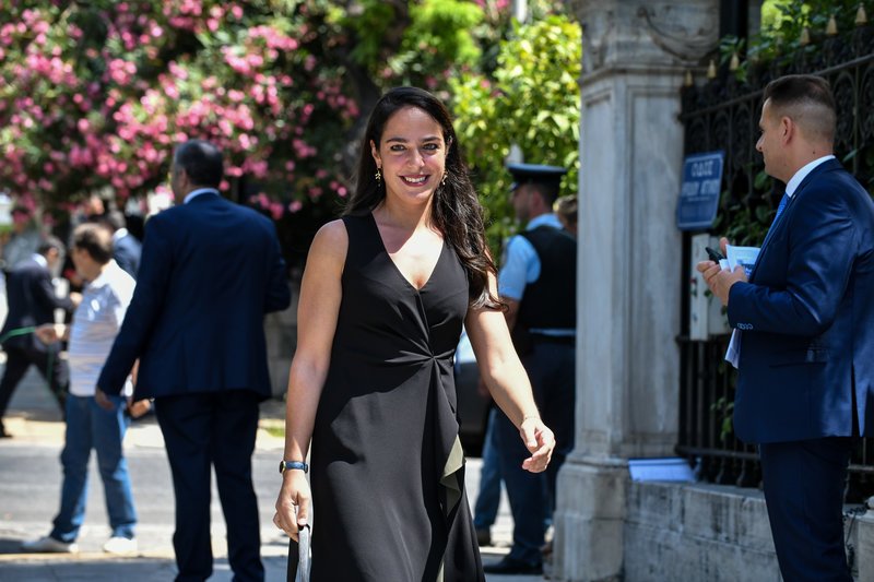 Η Δόμνα Μιχαηλίδου επέλεξε ένα μαύρο midi φόρεμα σε κλασική γραμμή με κόψιμο στο λαιμό σε σχήμα V.