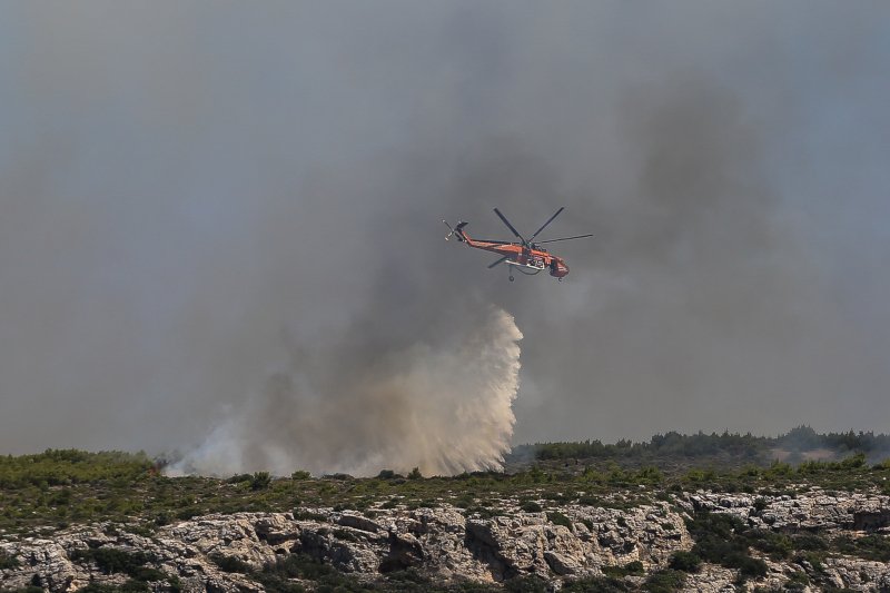 Ελικόπτερο ρίχνει νερό πάνω από φωτιά στο Λαύριο