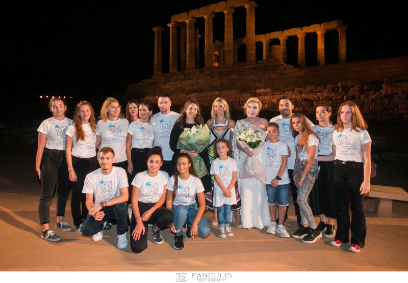 Η Μαίρη Κατράντζου, η Μαριάννα Βαρδινογιάννη και τα παιδιά του Συλλόγου Ελπίδα, με φόντο το ναό του Ποσειδώνα στο Σούνιο