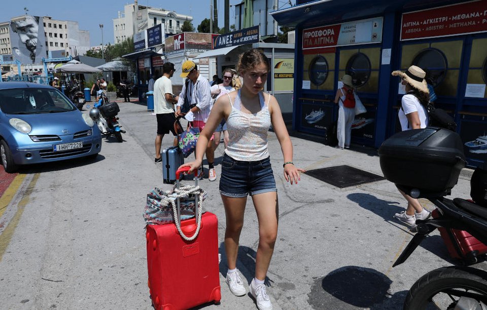 Τουρίστες ετοιμάζονται να επιβιβαστούν σε πλοίο της γραμμής στο λιμάνι του Πειραιά