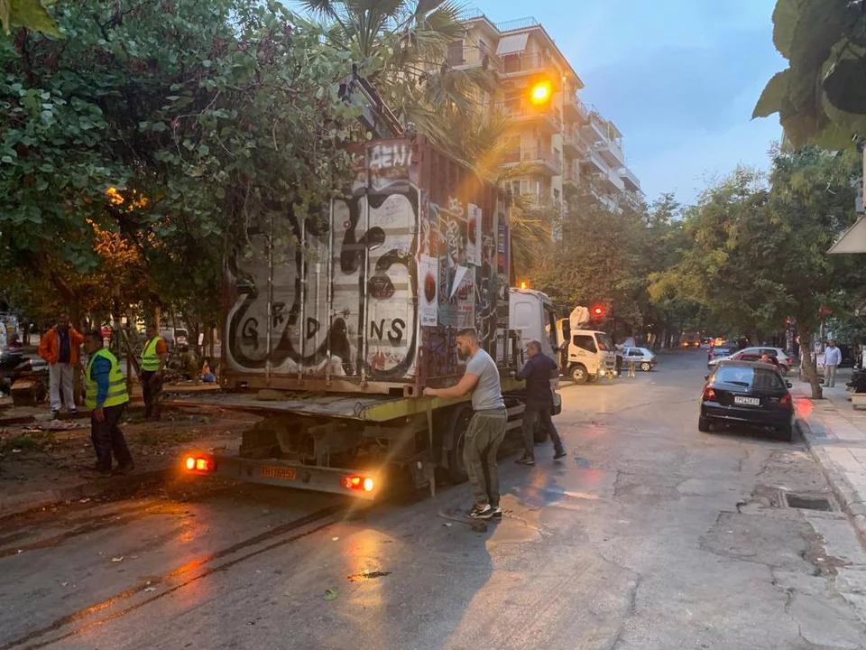 Υπάλληλοι του δήμου απομακρύνουν το κοντέινερ από την πλατεία Εξαρχείων