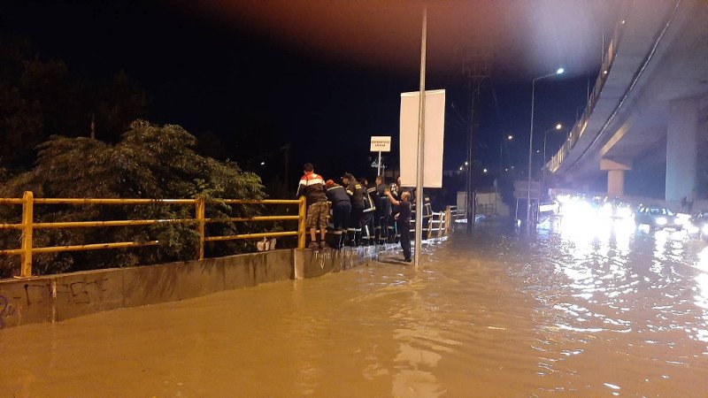 Πυροσβέστες κοιτάζουν κάτω σε δρόμο πλημμυρισμένο