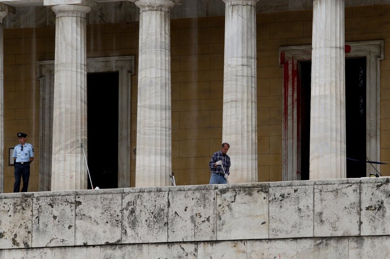 Με μία σφουγγαρίστρα στο χέρι υπάλληλος καθαρίζει τα σκαλιά στη Βουλή