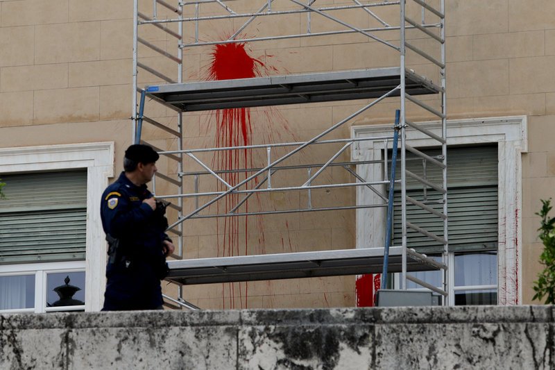 Αστυνομικός έξω από τη βανδαλισμένη Βουλή κοιτάζει σκαλωσιές και μπογιές