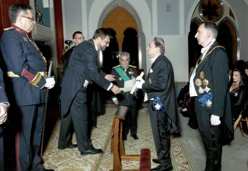 Ο κος Γιώργος Λενός λαμβάνει το χρίσμα του Ιππότη, διά ξίφους, από τον πρίγκιπα Ερρίκο της Ισπανικής Βασιλικής Δυναστείας των Βουρβόνων, συνοδευόμενος από τον Βαρώνο Breidel