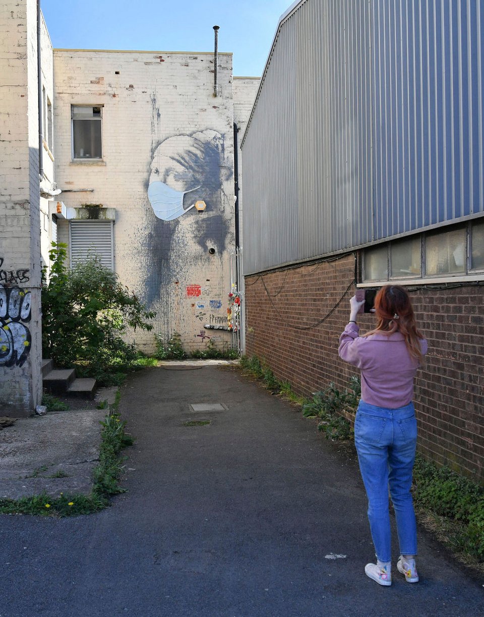 Γυναίκα φωτογραφίζει το έργο του Banksy στο Μπρίστολ