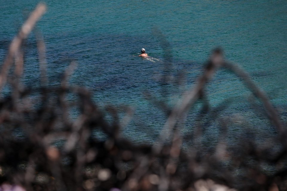 Γυναίκα με καπέλο κολυμπά στη θάλασσα