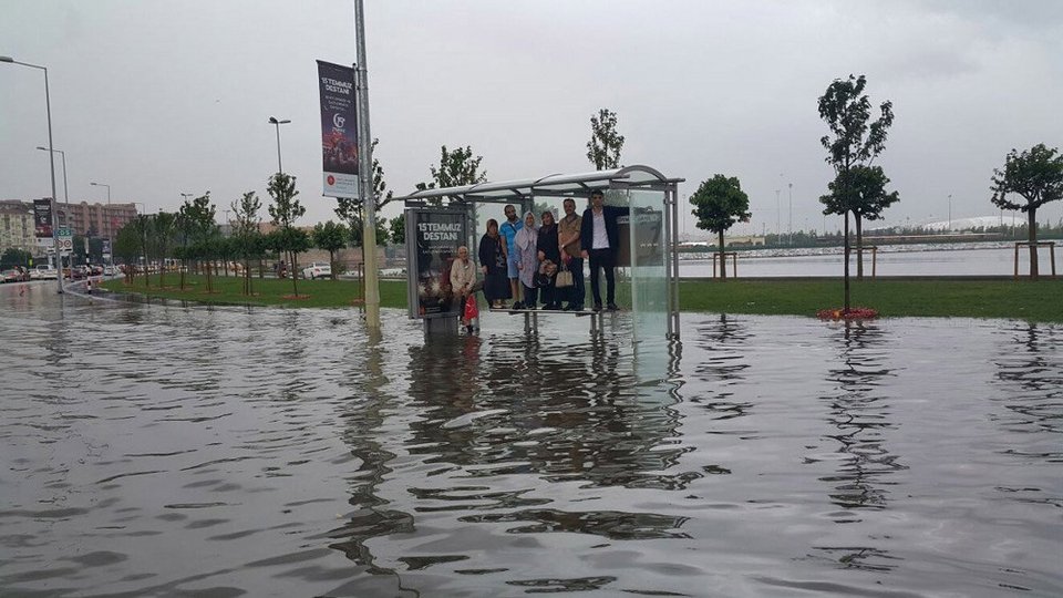 Επιβάτες λεωφορείου περιμένουν επάνω σε στάση λόγω των πλημμυρισμένων δρόμων