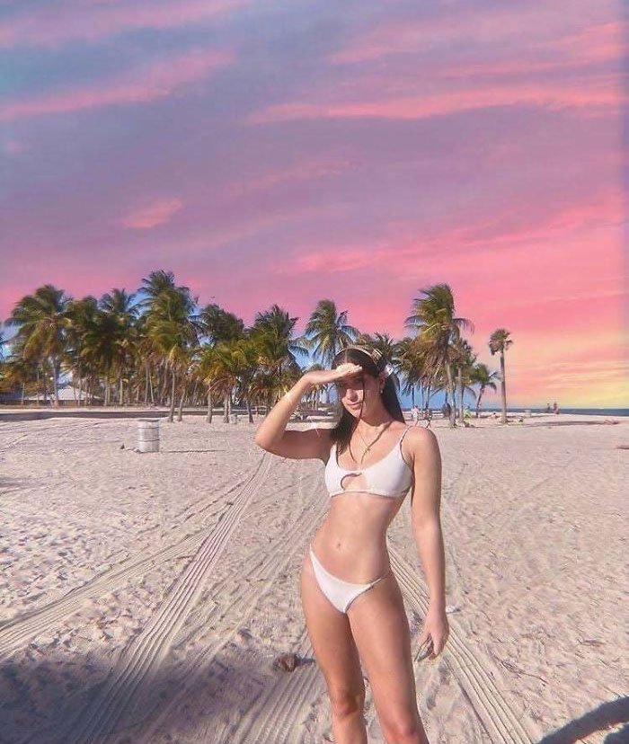 Γυναίκα ποζάρει με μπικίνι με φόντο το ηλιοβασίλεμα