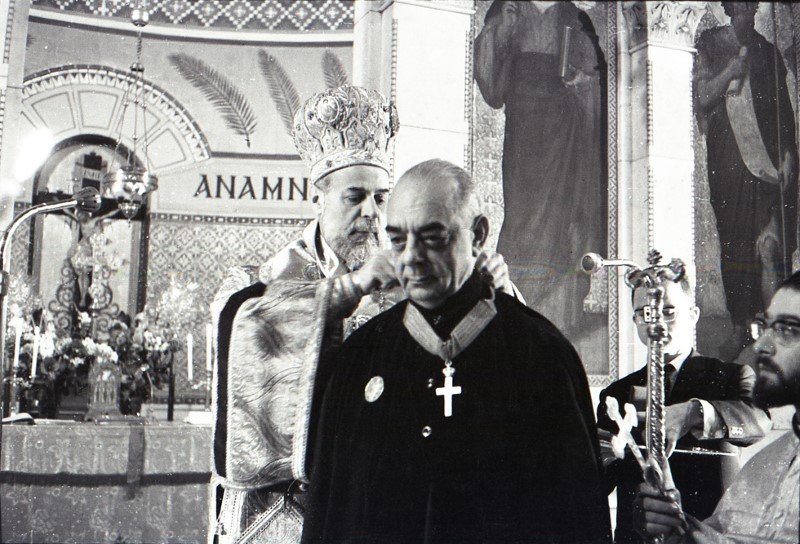 O Μητροπολίτης Γαλλίας, Μελέτιος, περνά Μεγαλόσταυρο στον λαιμό του Αναστασίου Λεβέντη