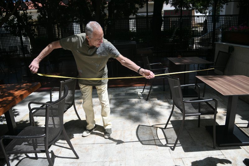 Καταστημάταρχης στην Κηφησιά μετρά τις αποστάσεις μεταξύ των τραπεζιών/ Φωτογραφία: Eurokinissi