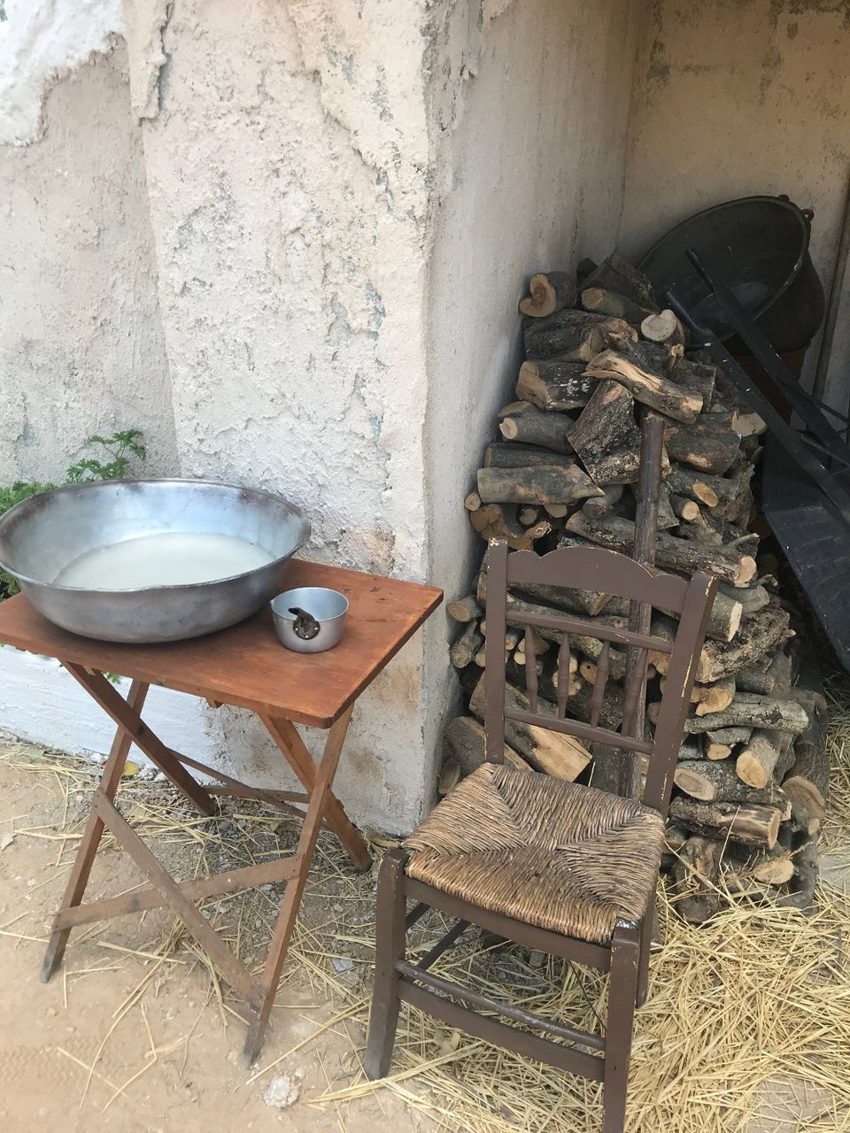 Μια παλιά καρέκλα με ψάθινη θέση και γαλβανισμένα σκεύη στο σκηνικό της σειράς «Άγριες Μέλισσες»