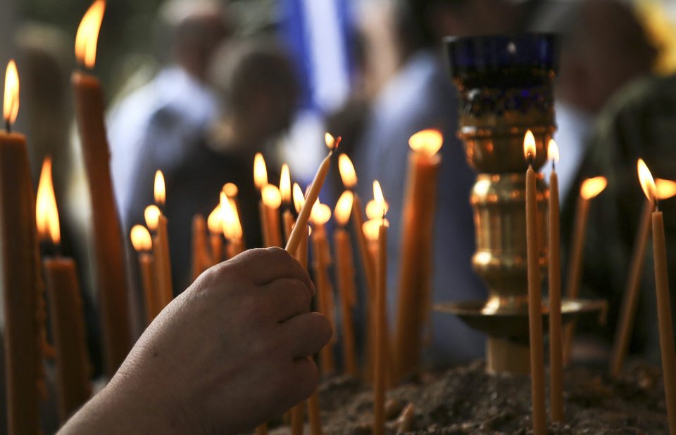 Πιστός ανάβει κερί σε ορθόδοξο ναό