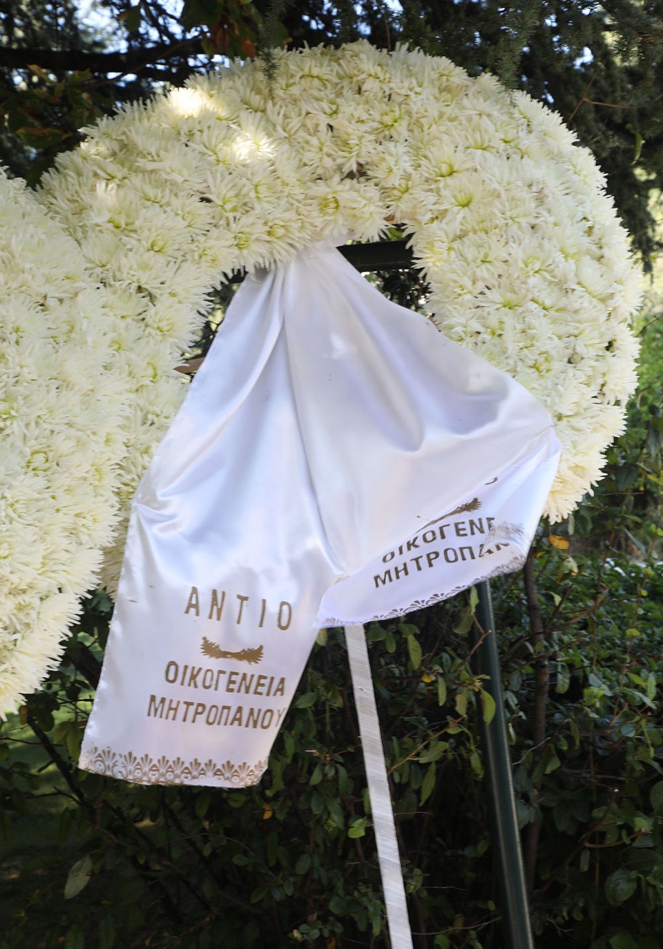 Ανάμεσα στα στεφάνια στην κηδεία του Γιάννη Πουλόπουλο και ένα από την οικογένεια Μητροπάνου