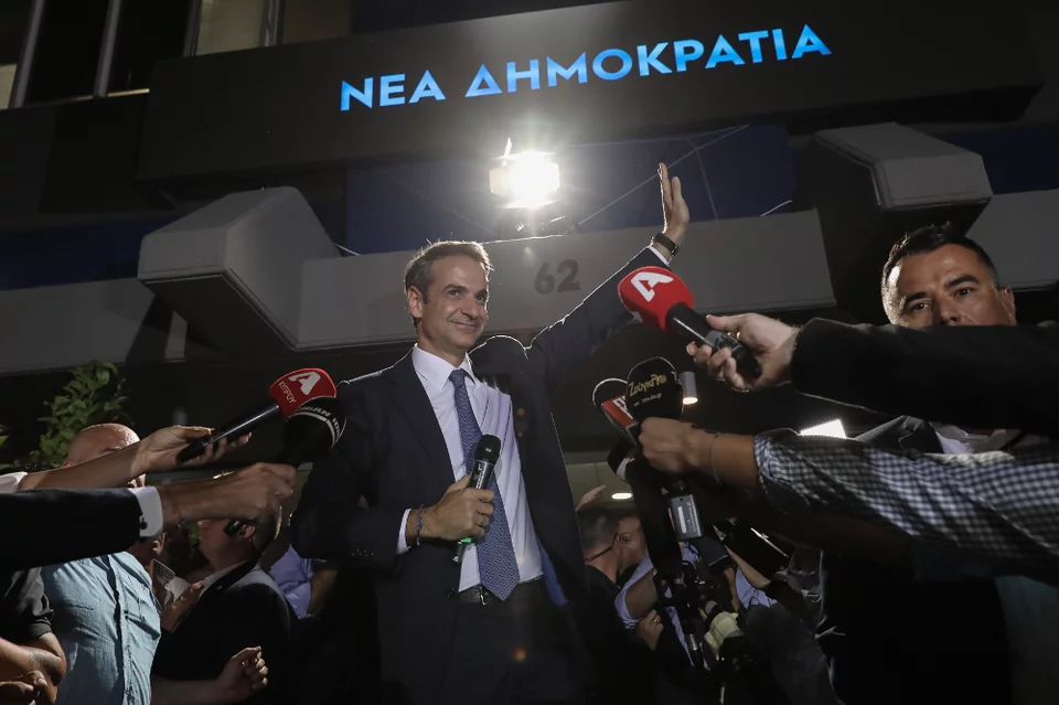 Ο Κυριάκος Μητσοτάκης χαιρετά τους οπαδούς του κόμματός του έξω από τα γραφεία της ΝΔ