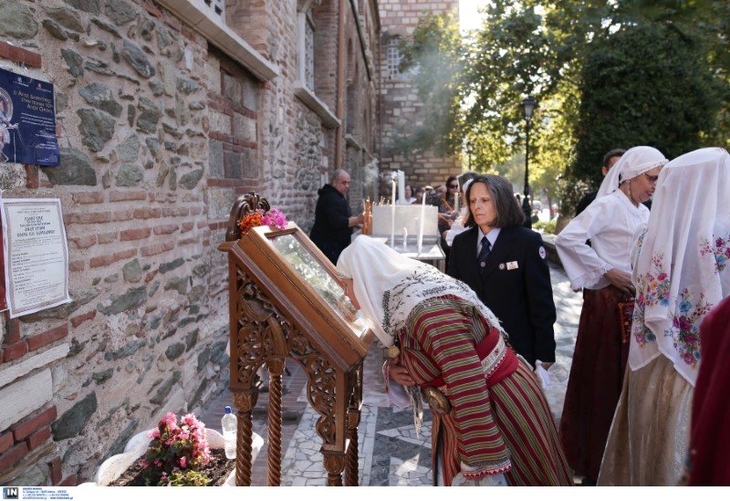 Κοπέλα με παραδοσιακή στολή προσκυνά εικόνα