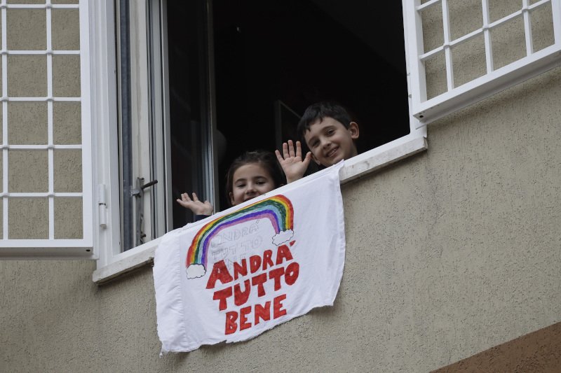 Παιδιά σε μπαλκόνι στην Ιταλία με πανό με ουράνιο τόξο