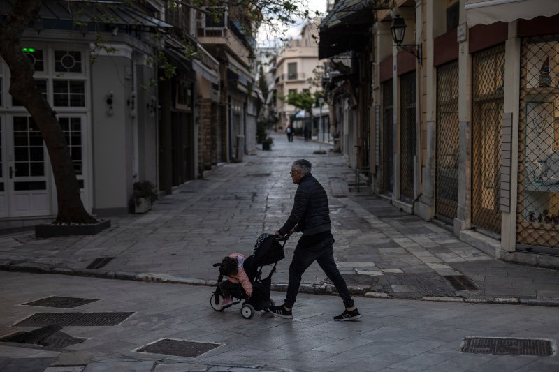 παππούς σπρώχνει καροτσάκι μωρού στην άδεια Αθήνα