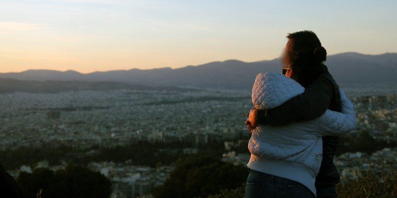 Ζευγάρι απολαμβάνει αγκαλιά το δειλινό από το λόφο του Λυκαβηττού