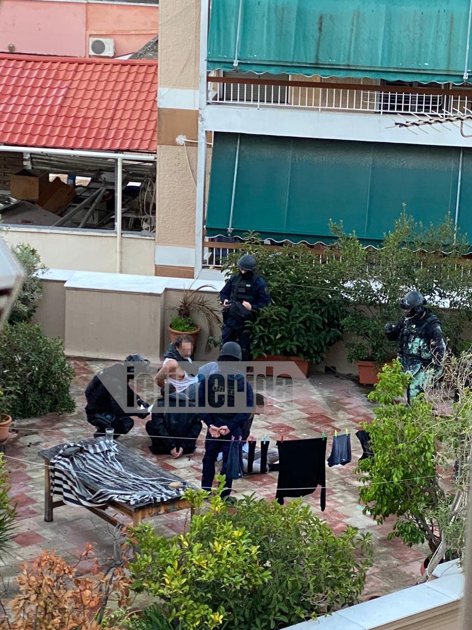 Η ομάδα της ΟΠΚΕ στην ταράτσα της οικογένειας Ινδαρέ με τον πατέρα και τους γιος να είναι στο έδαφος δεμένοι πισθάγκωνα