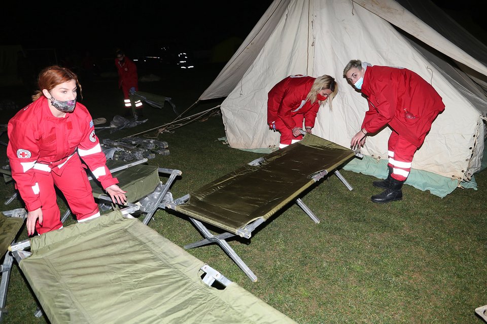 Μέλη του Ερυθρού Σταυρού μεταφέρουν κρεβάτια