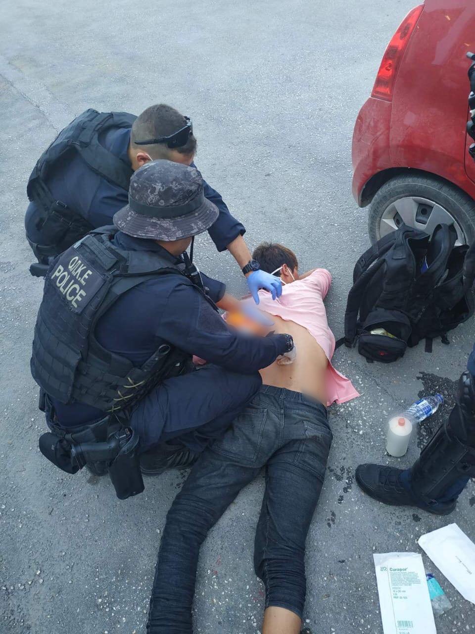 Οι αστυνομικές δυνάμεις δίνουν τις πρώτες βοήθειες στον μαχαιρωμένο Αφγανό