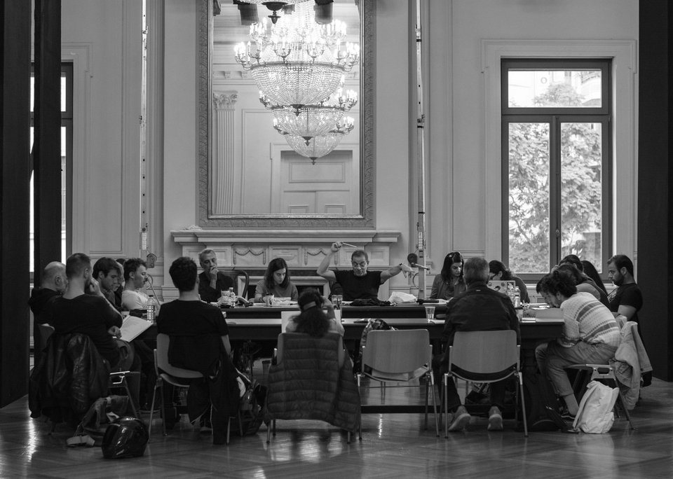 Ολοι οι συνεργάτες της παράστασης γύρω από ένα τραπέζι ακούν τις πρώτες οδηγίες του Δημήτρη Λιγνάδη / Φωτογραφία Πέννη Καραχάλιου