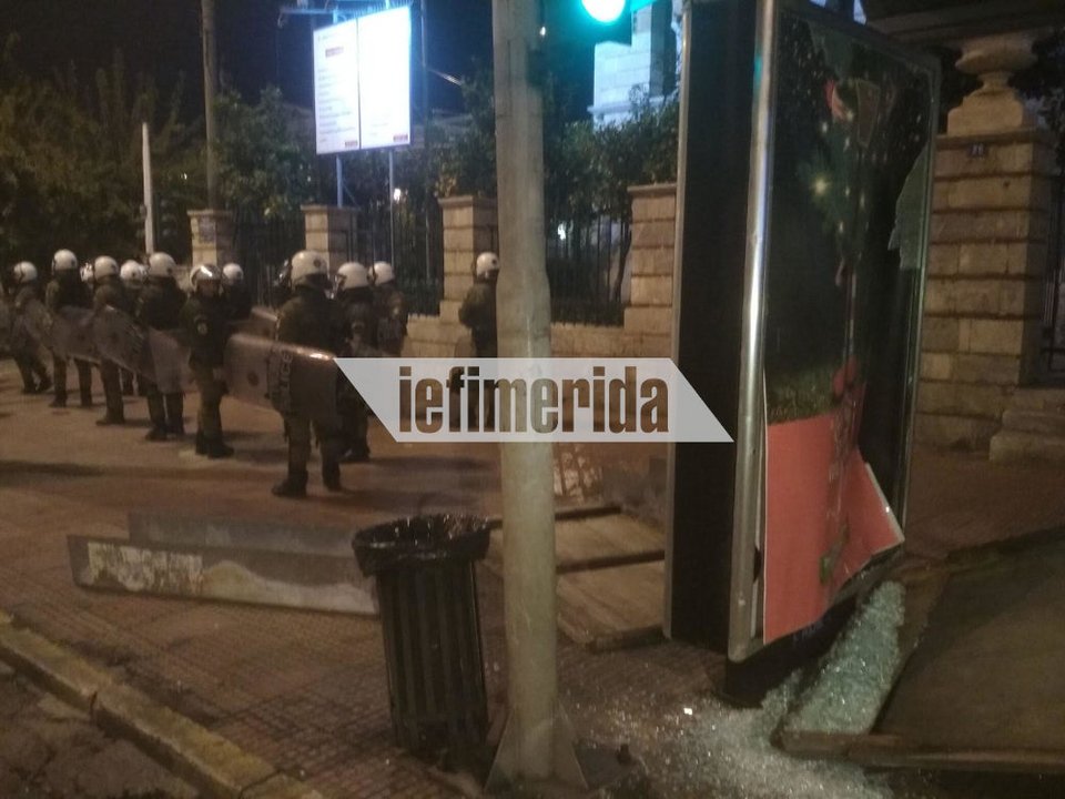 Διμοιρία των ΜΑΤ περνά μπροστά από σπασμένη στάση στην Πανεπιστημίου