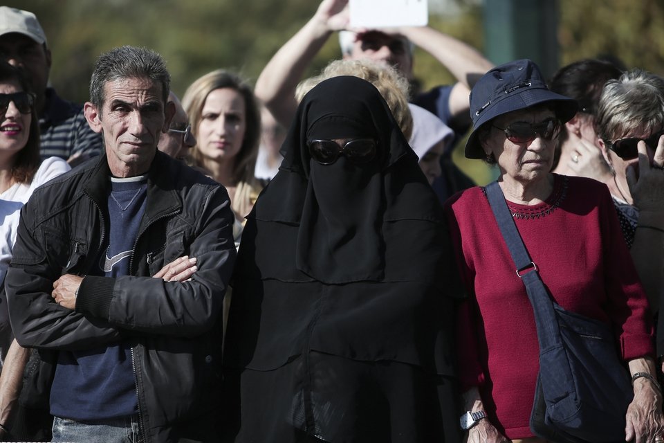Μία γυναίκα με νικάμπ παρακολουθεί την παρέλαση