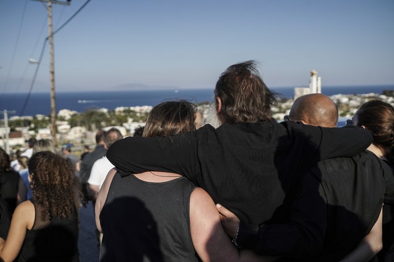 Αγκαλιασμένοι οι συγγενείς περπατούν ξανά στα καμμένα.