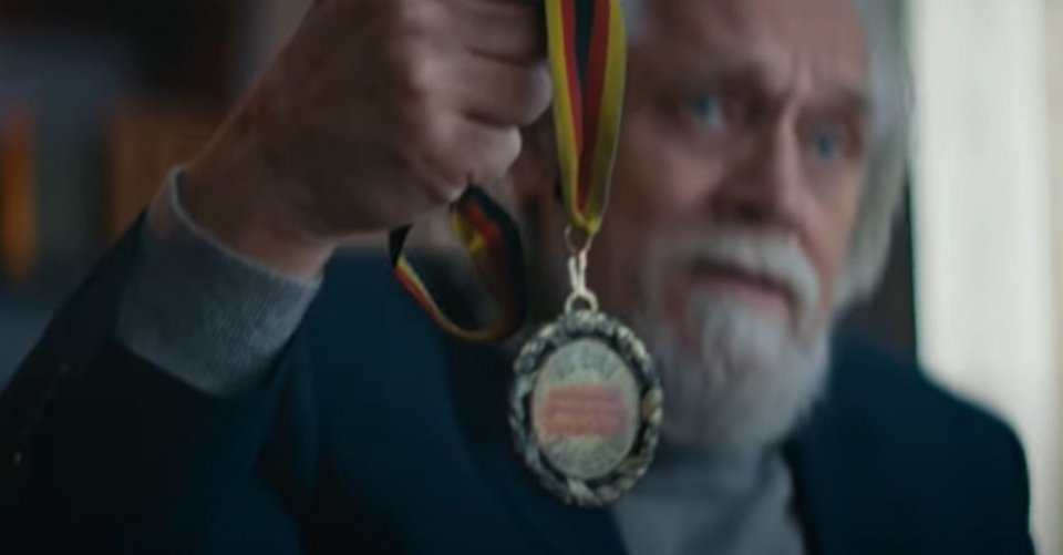 Ένας γενειοφόρος άνδρας κρατά το μετάλλιο ανδρείας που του απένειμε το γερμανικό κράτος το 2020