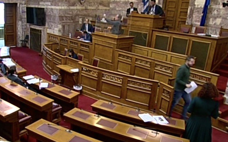 Η στιγμή που υπάλληλος της Βουλής καθαρίζει το εσωτερικό του πλεξιγκλάς με ειδικό απολυμαντικό