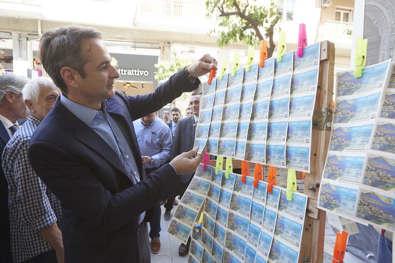 Ο Κυριάκος Μητσοτάκης αγοράζει λαχείο το οποίο χάρισε στον Ν. Βλαχάκο