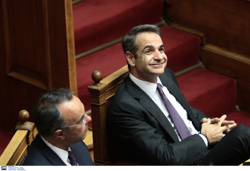 Ο Κυριάκος Μητσοτάκης χαμογελαστός στρέφει το βλέμμα στα θεωρεία