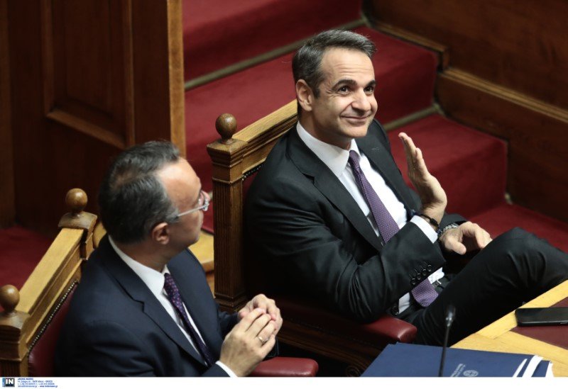 Ο πρωθυπουργός Κυριάκος Μητσοτάκης χαμογελαστός χαιρετά κάποιον στα θεωρεία