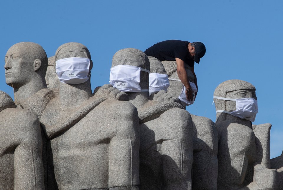 Εργαζόμενος βάζει μάσκες σε αγάλματα