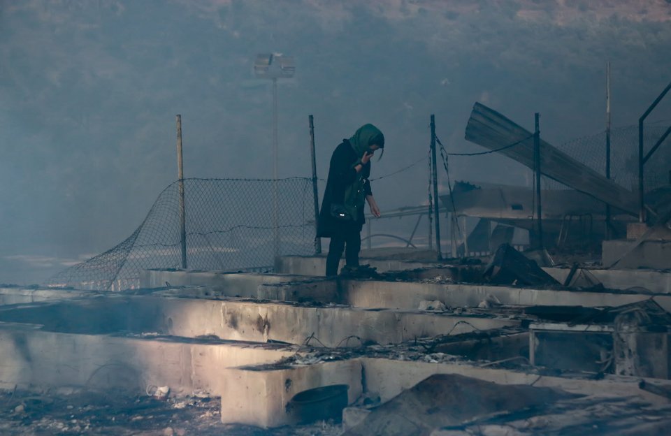 Μετανάστρια στέκεται στα αποκαϊδια στο ΚΥΤ της Μόριας