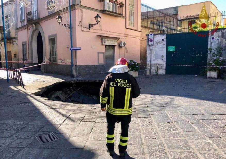 Πυροσβέστης μπροστά στην τεράστια τρύπα που άνοιξε σε δρόμο της Νάπολης.