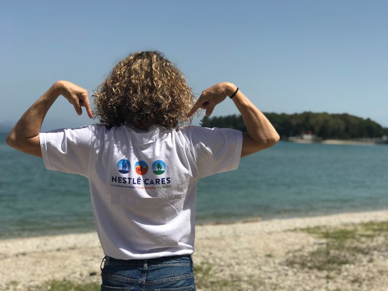 Nestle γυναίκα φορά μπλούζα στην παραλία με λογότυπο εταιρείας