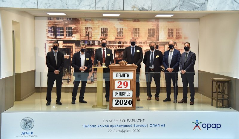 Ο Treasury Director του ΟΠΑΠ, Θανάσης Παναγιώτου, ο Αναπληρωτής Διευθύνων Σύμβουλος του ΟΠΑΠ, Οδυσσέας Χριστοφόρου, ο CFO του ΟΠΑΠ, Πάβελ Μούχα, ο Acting CEO του ΟΠΑΠ, Γιαν Κάρας, ο Διευθύνων Σύμβουλος του Ομίλου του Χρηματιστηρίου Αθηνών, Σωκράτης Λαζαρίδης, ο Διευθυντής Επενδυτικών Σχέσεων του ΟΠΑΠ, Νίκος Πολυμενάκος και ο Investor Relations Officer του ΟΠΑΠ, Γιάννης Παύλου.  