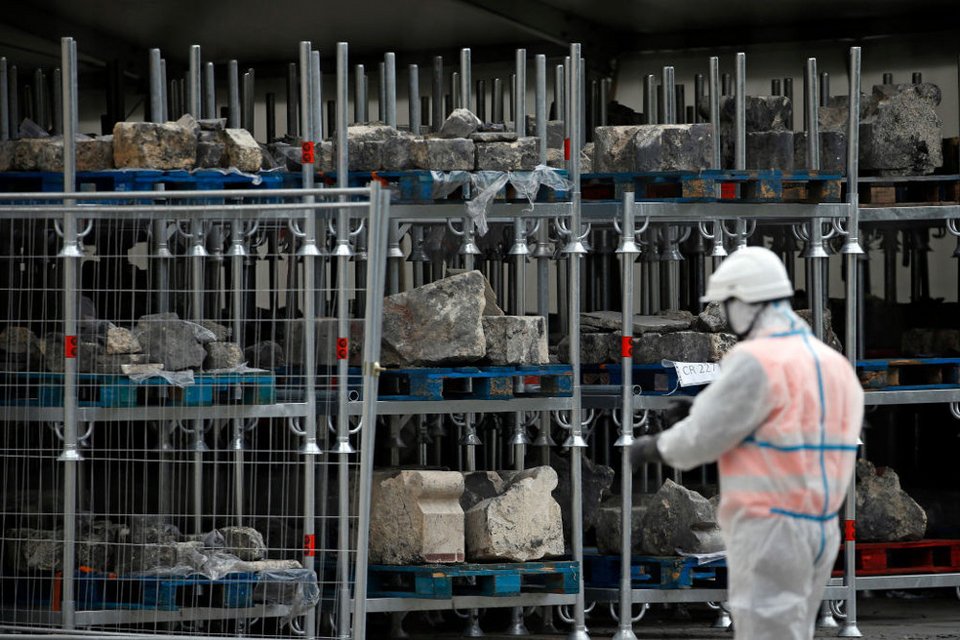 Εργάτες συγκεντρώνουν πέτρες και συντρίμμια από την Παναγία των Παρισίων όσο ξεκινούν δειλά - δειλά οι εργασίες αποκατάστασης