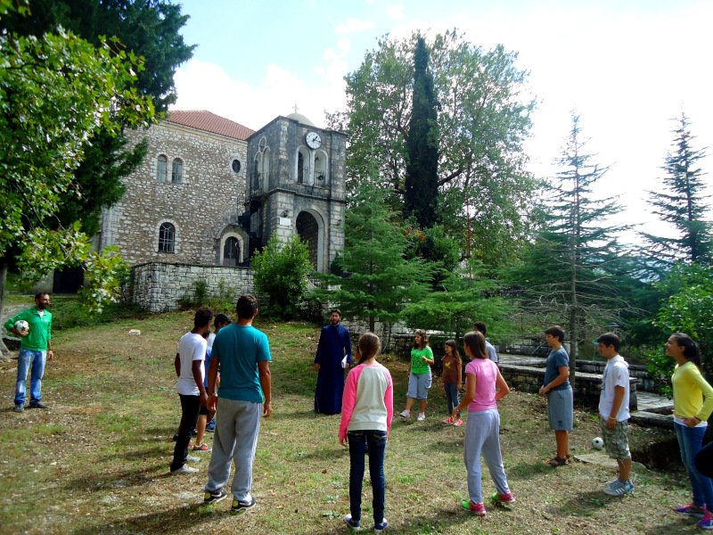 Ο πάτερ Αντώνιος όρθιος με παιδά