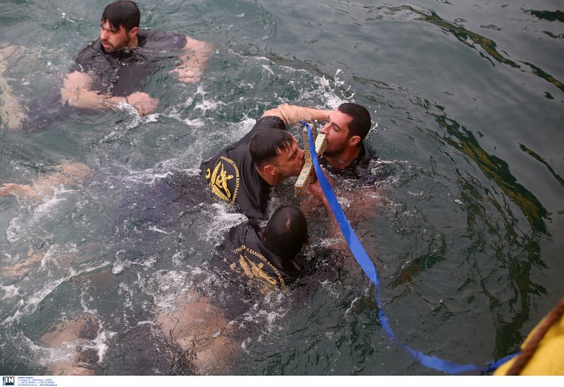 Αντρες φιλούν τον σταυρό μετά τον αγιασμό των υδάτων