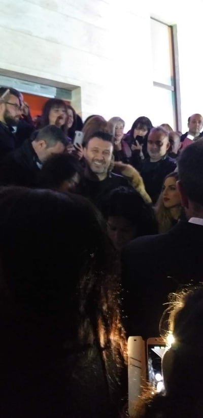 Ο Γιάννης Πλούταρχος συνομιλεί με κόσμο έξω από το νυχτερινό κέντρο