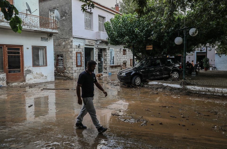 Πεζός περπατά στις λάσπες στο χωριό Πολιτικά