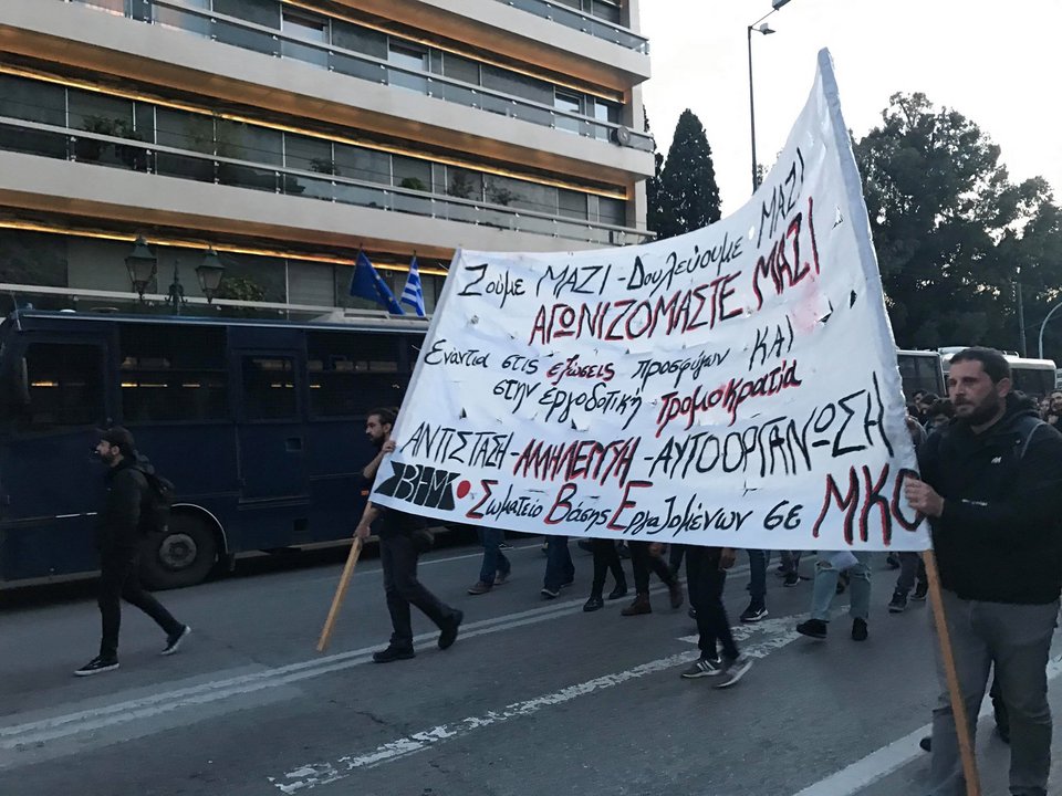 Πρόσφυγες με τα παιδιά τους κρατώντας πανό και πλακάτ διαμαρτύρονται.