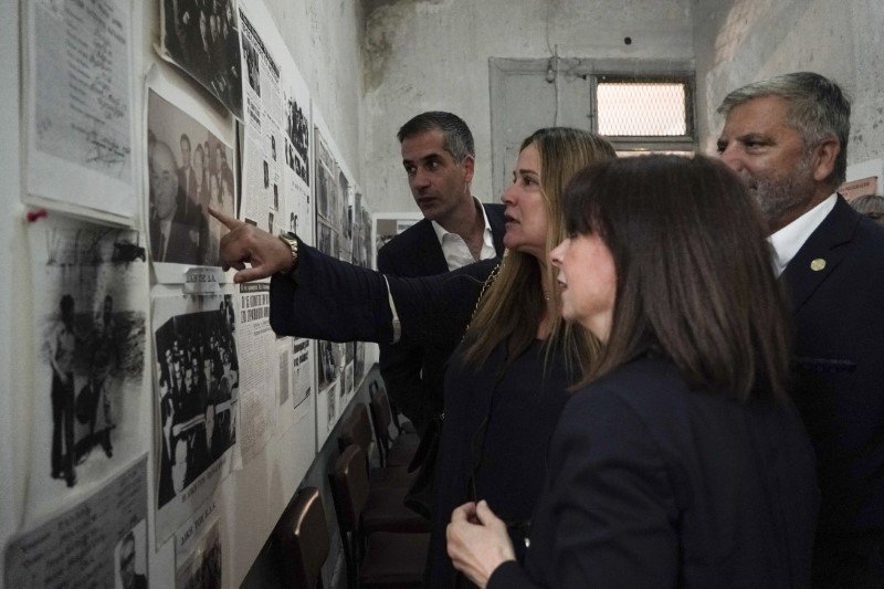 ΕΑΤ-ΕΣΑ: Η πρόεδρος του ΟΠΑΝΔΑ, Αννα Ροκοφύλλου δείχνει στην ΠτΔ, στον Κ. Μπακογιάννη και στον Γ. Πατούλη φωτογραφία με τον πατέρα της Χρήστο Ροκόφυλλο -Φωτογραφία: SOOC