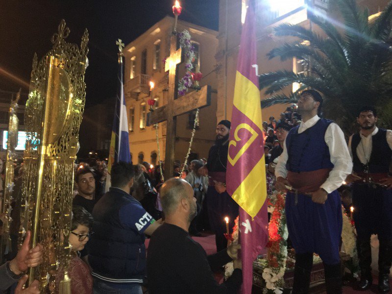 Αντρες με παραδοσιακές κρητικές φορεσιές στέκονται μπροστά στον σταυρό