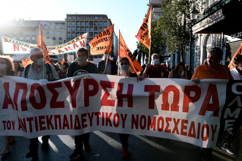 Διαδηλωτές και διαδηλώτριες με πανό στον δρόμο