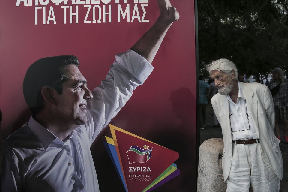 Ενας ηλικιωμένος κοιτάζει μια προεκλογική αφίσα του ΣΥΡΙΖΑ με τον Αλέξη Τσίπρα